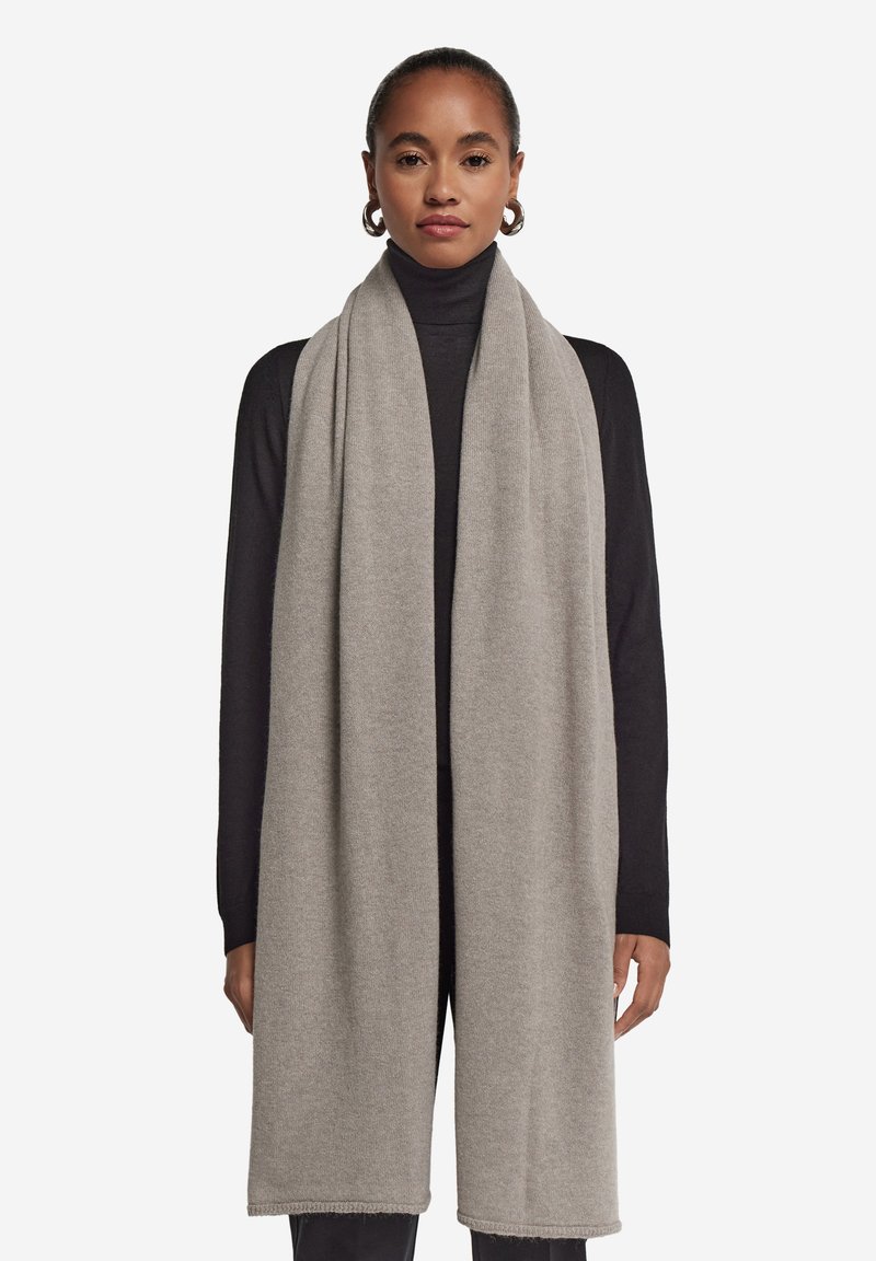 Lys grå tørklæde lavet af blødt stof, med et enkelt design, glat tekstur og færdige kanter, der hænger elegant omkring halsen.