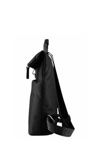 Bolso de hombro de tela negra con forma rectangular, correa ajustable, cierre de cremallera y superficie texturizada. Presenta un diseño minimalista.