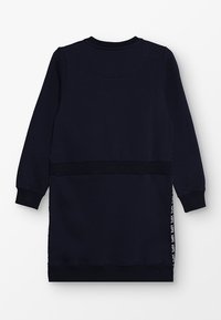 Granatowa sukienka dresowa z długimi rękawami, z prążkowanym dekoltem i mankietami oraz białym napisem "LOVE" biegnącym wzdłuż bocznego panelu.