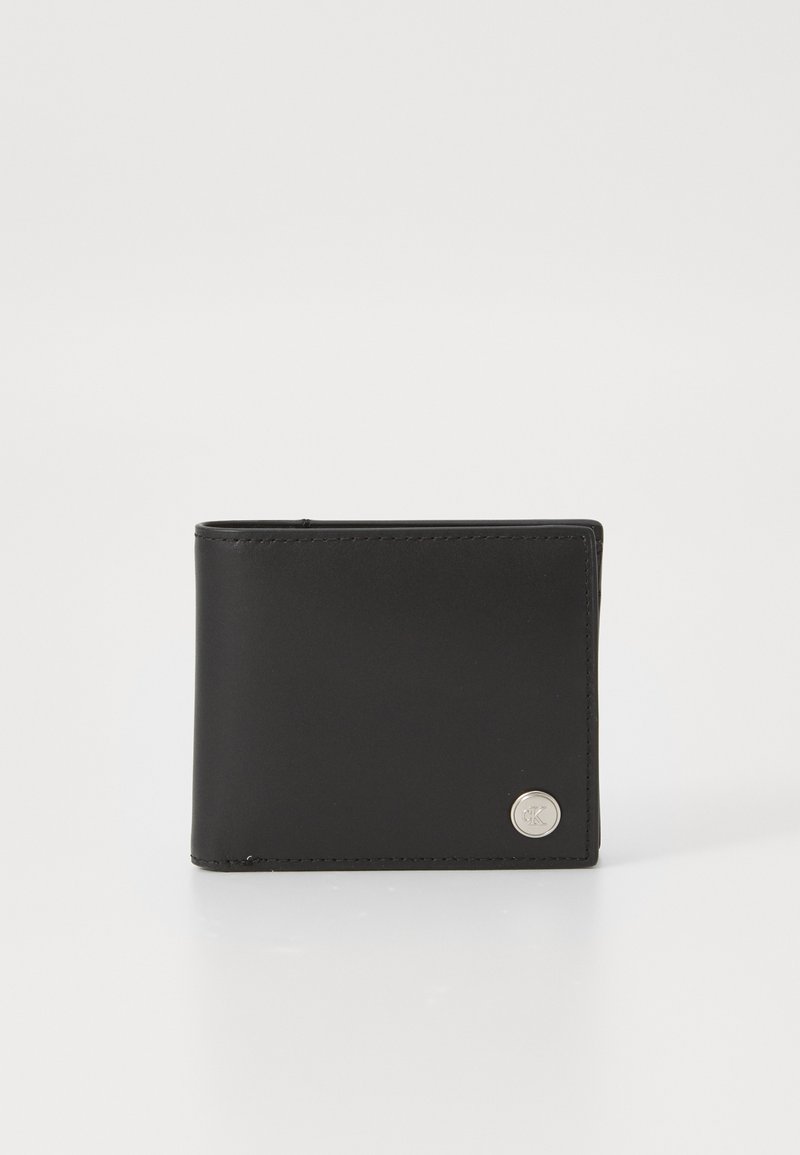 Portafoglio in pelle nera con design bi-fold, caratterizzato da un accento in logo argentato e linee pulite. Texture liscia senza motivi visibili.
