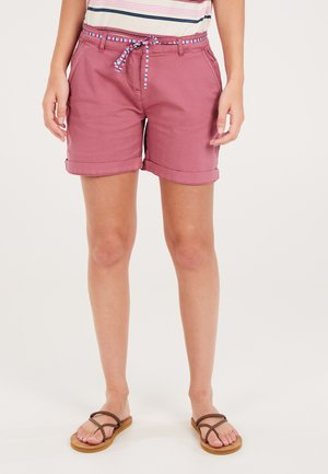 Shorts en coton rose avec une taille à cordon, ornés d'un accent à rayures multicolores. Ourlet roulé et poches latérales. Associés à des sandales marron.
