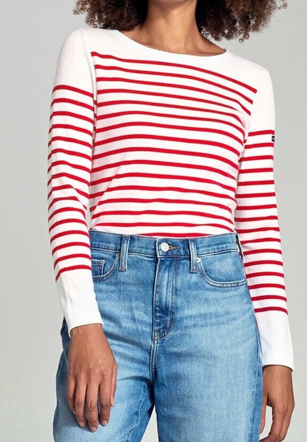 Gestreiftes Langarmshirt in rot und weiß mit rundem Ausschnitt, kombiniert mit hellblauen Jeans aus Denim. Weicher Stoff mit lässiger Passform.