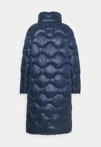 Lång marinblå vadderad vinterjacka med vågig sömnadsmönster, hög krage och långa ärmar, visad från baksidan.