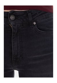 Jeans in denim nero con cerniera frontale, chiusura con bottone e tasche standard; il tessuto presenta una trama sottile con un taglio classico.