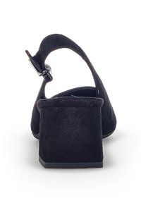 Scarpe con tacco in suede nero, con tacco quadrato e cinturino alla caviglia regolabile. La scarpa presenta una superficie liscia e un design minimalista.