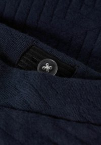 Donkerblauwe wol gebreide stof met een gestructureerd patroon, voorzien van een doorzichtige plastic knop en een zwart stoffen accent eronder.