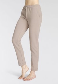 Lichtbeige sweatpants met een elastische tailleband en verstelbaar trekkoord. Ze hebben zij-naad en omgeslagen boorden bij de enkels.
