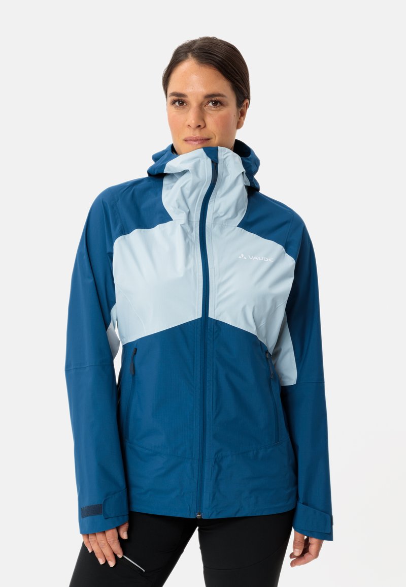 Giacca impermeabile blu con accenti azzurri, zip completa, cappuccio regolabile e tasche laterali. Presenta un mix di materiali lisci e testurizzati.