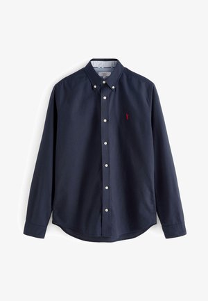 Chemise bleu marine à manches longues avec un col, boutons blancs et une petite broderie de homard rouge sur la zone gauche de la poitrine.