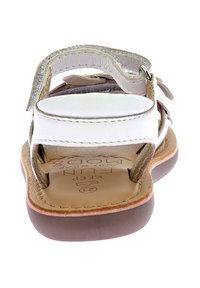 Sandal in pelle bianca con cinturini regolabili, suola marrone e soletta imbottita con impressione del nome del marchio.