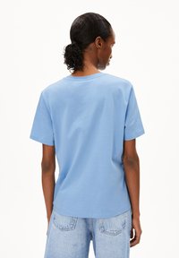 T-shirt en coton bleu clair avec un col rond, des manches courtes et une coupe décontractée, vu de l'arrière. Présente une texture simple et lisse.