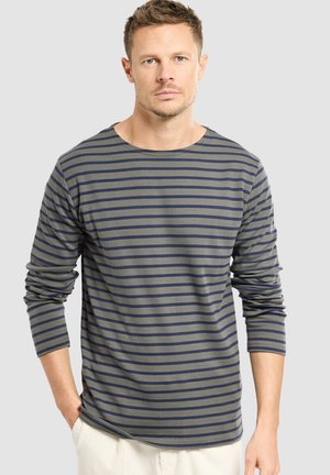 Olijfgroene longsleeve shirt met navy horizontale strepen, voorzien van een ronde hals en een ontspannen pasvorm. Zachte stof met zijsplitten.
