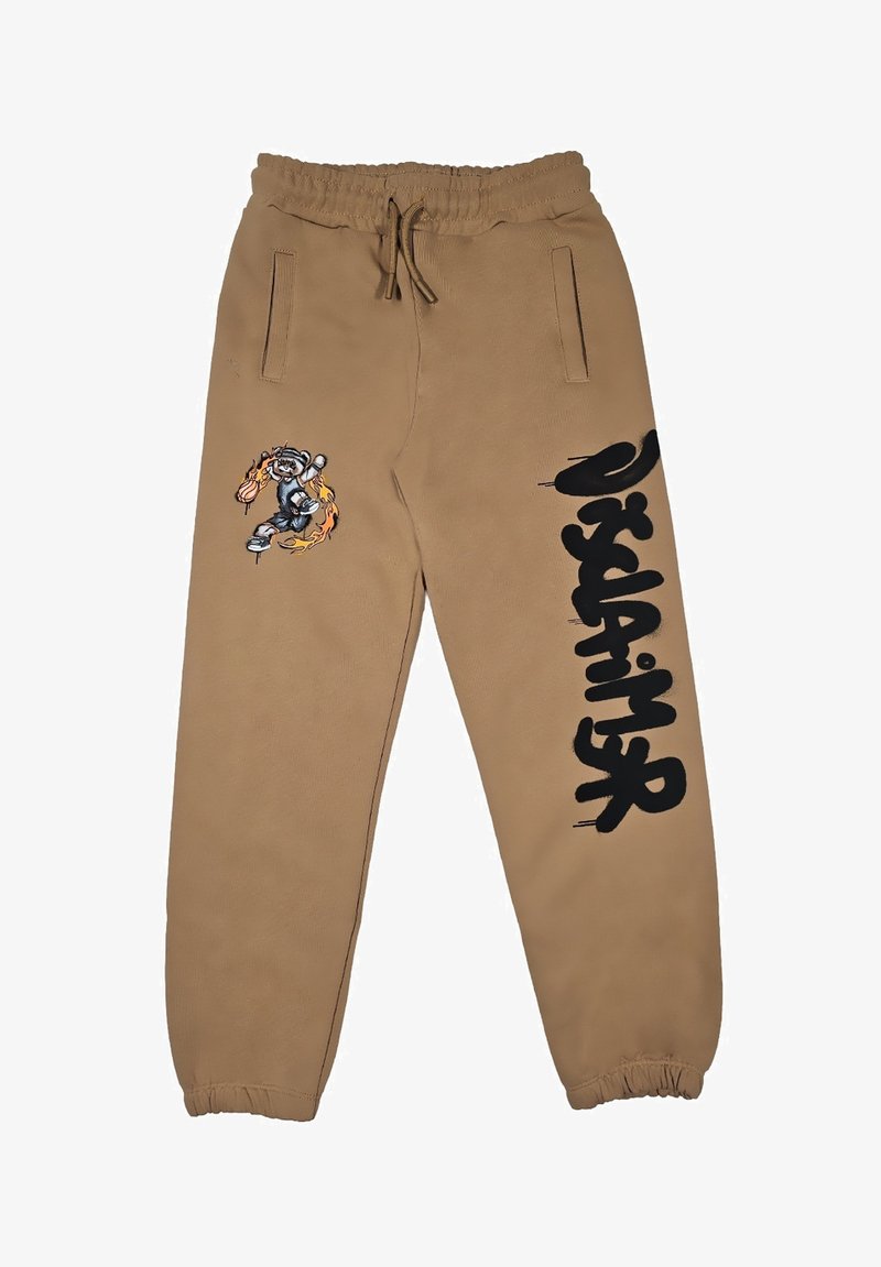 Pantaloni felpati marroni con vita elastica, tasche laterali, caratterizzati da una grafica in stile cartoon e testo nero sulla gamba sinistra. Texture morbida, polsini svasati.