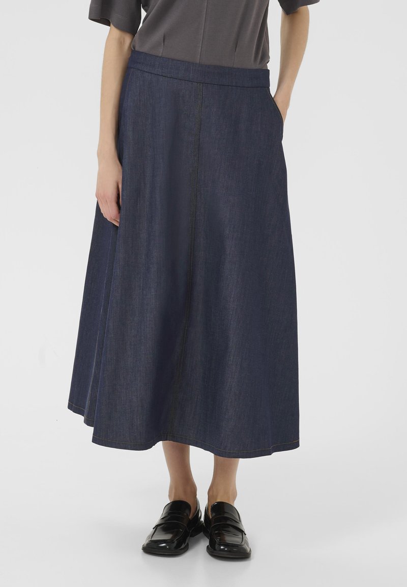 Fustă maxi din denim de culoare albastru închis, cu o textură netedă, siluetă largă, buzunare laterale și detalii de cusătură galbenă în contrast.