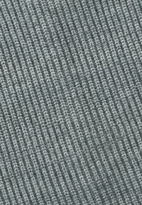 Tissu gris muted avec une texture côtelée. Le matériau semble doux et dense, montrant des lignes verticales réparties uniformément.
