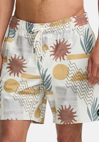 Pantaloni da nuoto in un tessuto leggero con cintura elastica, caratterizzati da un motivo geometrico multicolore con motivi di sole e foglie.