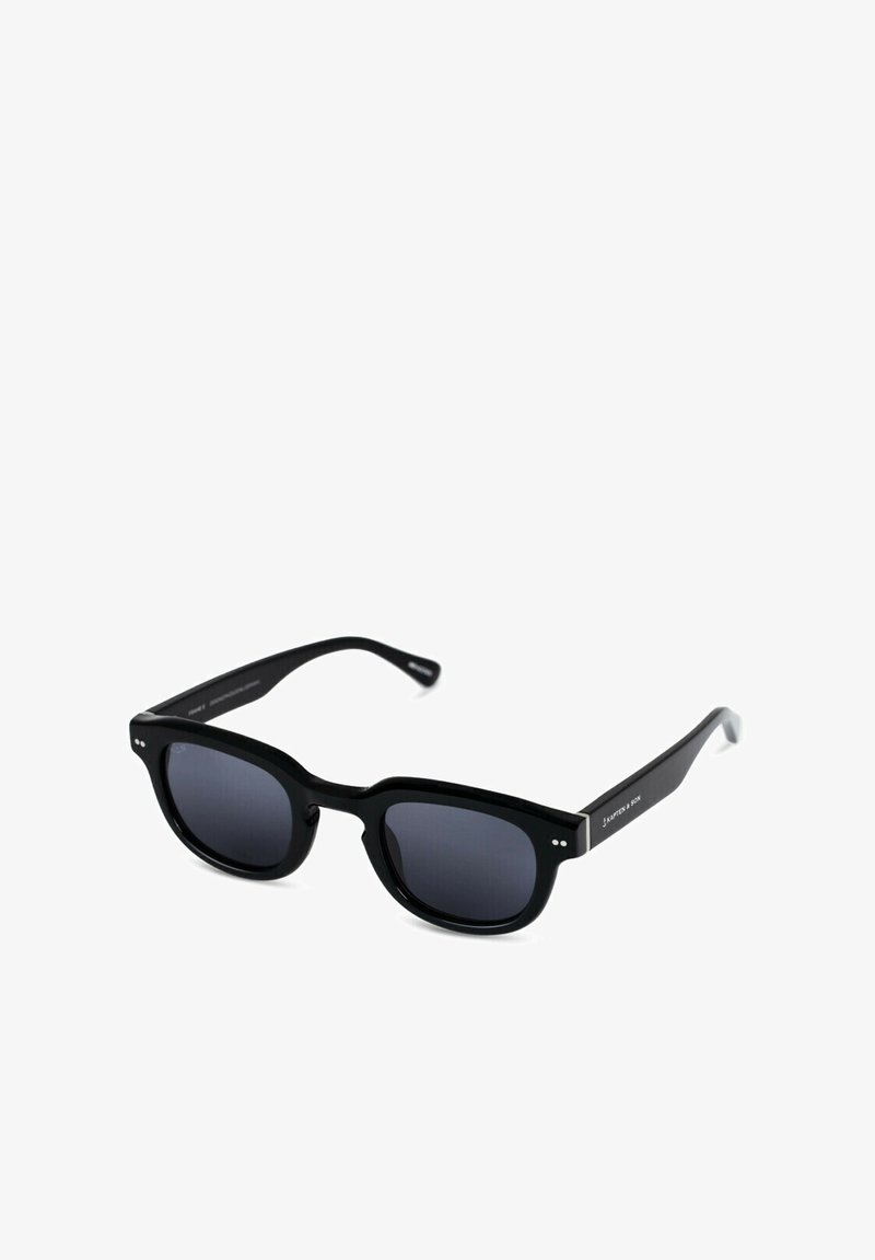 Occhiali da sole neri con montatura quadrata, lenti oscurate e sottili bracci neri con un branding discreto e dettagli decorativi.