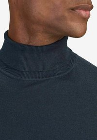 Mörk marinblå turtleneck-tröja med en nära passform kring kragen, slät textur och ribbade detaljer vid halsringningen och nederkanten.