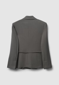 Grauer Blazer mit strukturierter Silhouette, aufgesetzten Revers und einem Schlitz hinten. Robustes Material mit glatter Textur und minimalistischem Design.