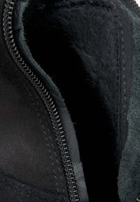 Zwarte suede laarzen binnenkant met een gladde synthetische voering, ritssluiting en een zachte, vachtachtige textuur langs de rand.