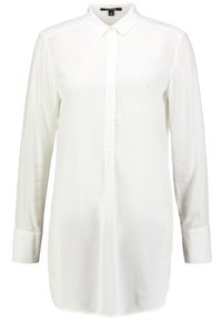 Chemise blanche à manches longues en tissu léger, avec un col, une patte de boutonnage sur le devant et un ourlet arrondi.