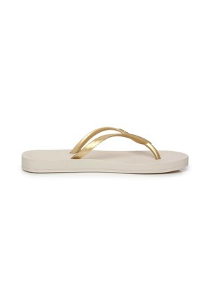 Infradito beige con suola piatta e cinturini metallici dorati a forma di Y.