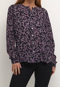 Knap-bluse i navy med blomstermønster i lilla og pink. Lange ærmer med knapmanchetter. Letvægts, tekstureret stof.