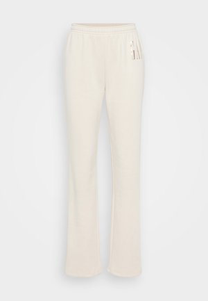 Pantaloni de trening de culoare crem, confecționați dintr-un material moale, cu o croială lejeră, talie elastică și un accent decorativ cu logo pe lateral.