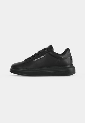 Μαύρο sneaker χαμηλής κοπής με χοντρή σόλα, μαύρα κορδόνια και λευκή σήμανση "KARL LAGERFELD" στο πλάι.
