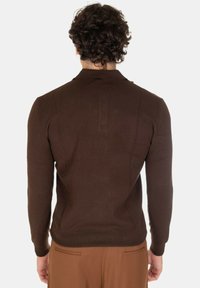 Maglione a maglia marrone con maniche lunghe e un colletto sottile, mostrato di spalle. Tessuto morbido, design aderente e dettagli minimi.