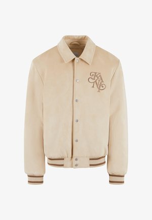 Beige suede bomberjakke med krave, trykknapper og broderet logo på brystet. Ribkanter og kant i kontrasterende brune striber.