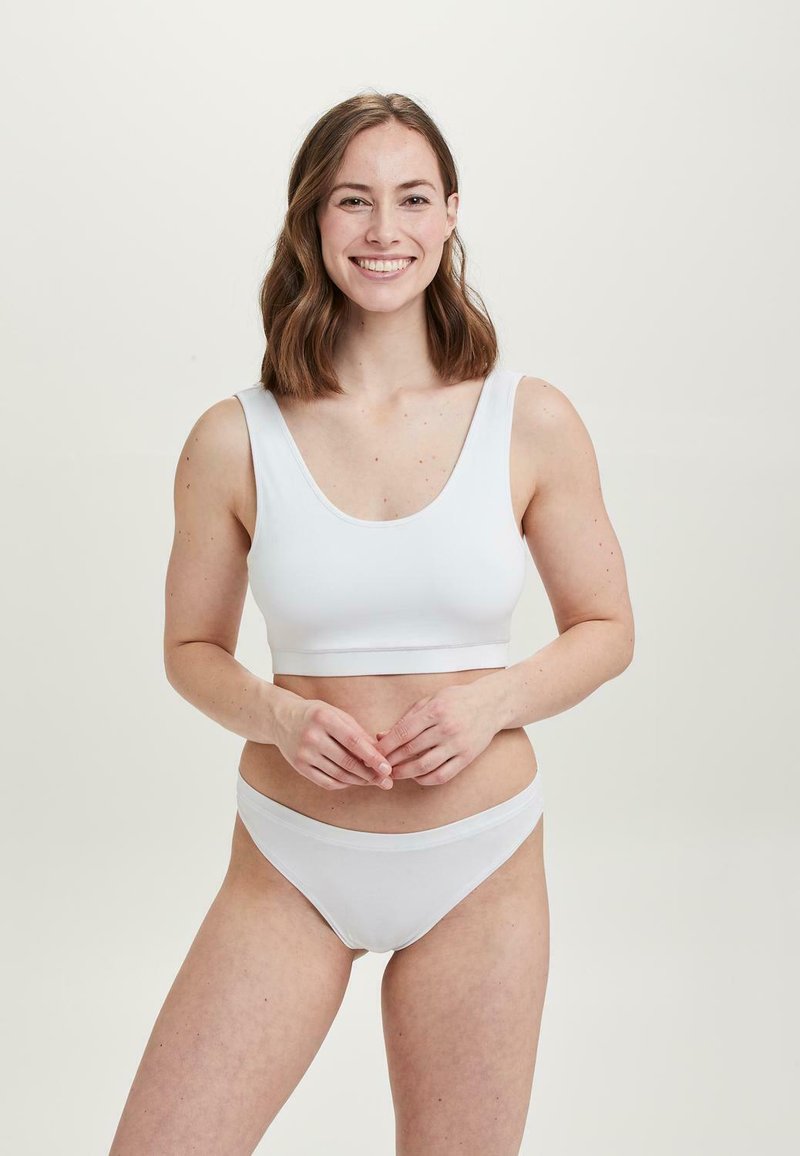 Hvid bomulds crop top med brede stropper og en lav scoop-udskæring, parret med matchende lavtaljede bikini-bukser, glat tekstur, minimalistisk design.