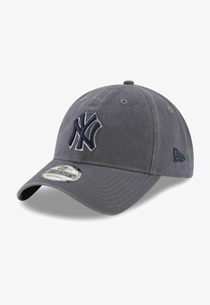 Grå baseball-kasket med en buet skygge. Har et stort broderet NY-logo i marineblå. Justerbar rem på bagsiden med et struktureret stof.