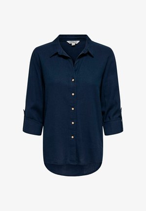 Tume sinine pika varrukaga särk kraega, esiküljel kuus beeži nööpi ja käärutatavate varrukatega, millel on nööbiga kinnitused.