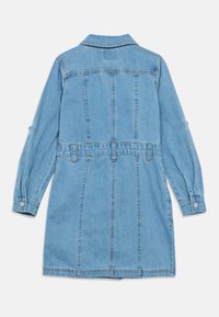 Φόρεμα από ανοιχτό μπλε τζιν με μακριά μανίκια, γιακά και ζωνάκι στη μέση. Διαθέτει κάθετες ραφές και μανσέτες με κουμπιά. Ομαλή υφή.