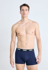 Boxeri navy din material neted, cu un design ajustat. Prezintă un brâu contrastant negru cu branding alb "PUMA".