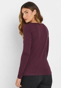 Maran pitkähihainen T-paita, jossa on pyöreä pääntie ja istuva muotoilu, valmistettu pehmeästä kankaasta. Ominaisuuksiin kuuluu pitkät hihat ja suora helma.