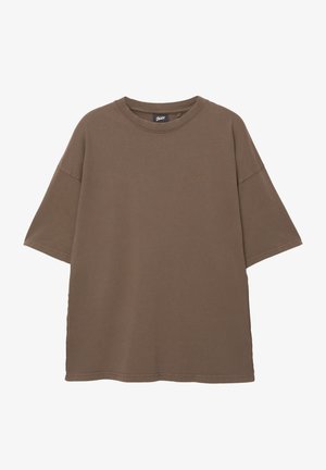 Barna, túlméretes pamut póló. Rövid ujjú, kerek nyakkivágással rendelkezik, és finom logó hímzés található rajta, azonos árnyalatban.