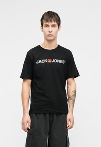 Černé bavlněné tričko s bílým a červeným logem "JACK & JONES". Klasický střih s krátkými rukávy a kulatým výstřihem.