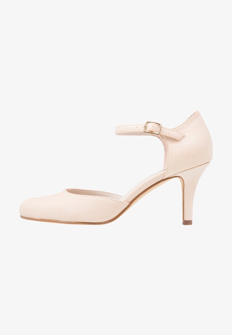 Beżowy but na wysokim obcasie z gładką cholewką i teksturowanymi detalami. Posiada regulowany pasek wokół kostki i smukły obcas.