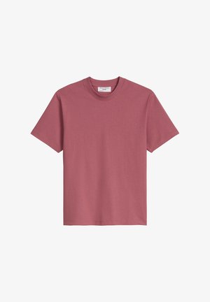 Koszulka z krótkim rękawem w kolorze pudrowego różu. Wykonana z miękkiej bawełnianej tkaniny. Klasyczny okrągły dekolt, standardowy krój i prosty dół.