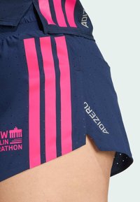 Nieco granatowe szorty do biegania z różowymi pionowymi paskami, perforowanym wzorem dla wentylacji oraz bocznym rozcięciem dla swobody ruchów. Zawierają logo "ADIZERO".