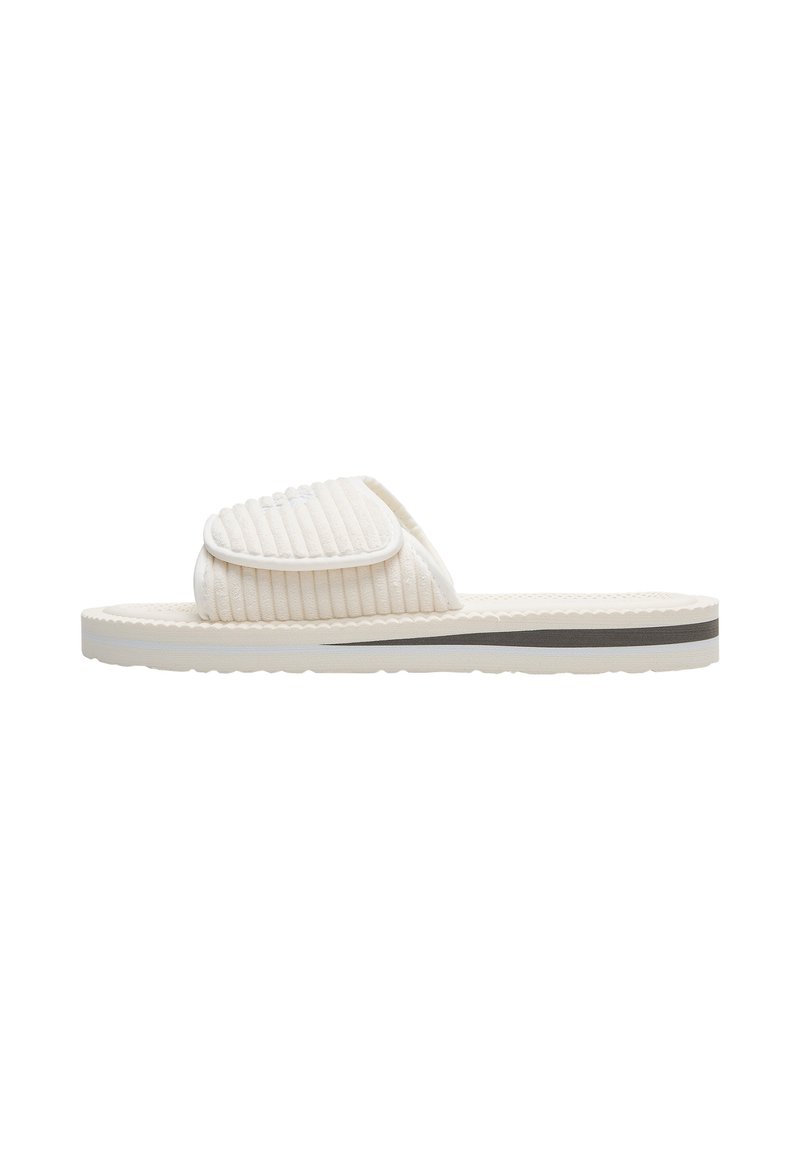 Light beige slide sandal with a ribbed upper, padded strap, and a contrasting dark stripe on the sole. Textured rubber sole for grip.
