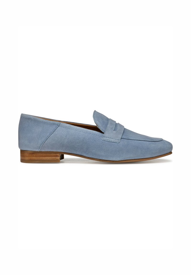 Mocassins en daim bleu avec un talon plat marron, présentant une couture décorative sur le dessus et un bout arrondi. Texture lisse, design épuré.