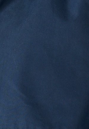 Marineblauwe stof met een gladde textuur en een diagonale ribbelpatroon, dicht geweven, geschikt voor bekleding of buitenkleding.