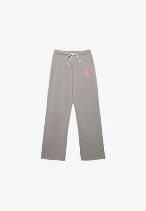 Svetlosivé teplákové nohavice s bielym sťahovacím šnúrkou a ružovým nápisom "NYC" na hornej ľavej stehnej časti, s bočnými vreckami a širokými nohavicami.