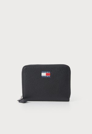 Portefeuille en cuir noir texturé avec une fermeture éclair et un petit logo rectangulaire Tommy Jeans en rouge, blanc et bleu sur le devant.