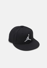 Sort baseball cap lavet af stof, med en flad skygge, broderet hvid Jumpman-logo på fronten og ventilationshuller.