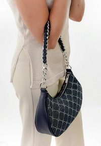 Borsa hobo nera e blu con design trapuntato, dotata di tracolla in pelle intrecciata e dettagli in catena argentata. Apertura con zip sulla parte superiore.
