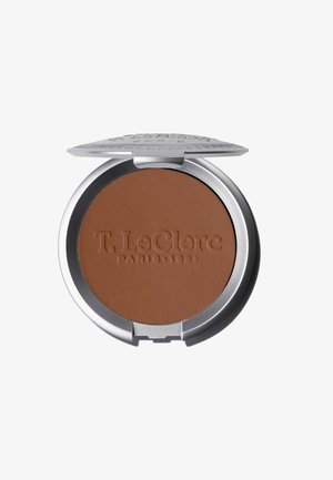 Bronzer compatto in confezione argento con marchio in rilievo. Colore marrone caldo, opaco e liscio. Coperchio a cerniera per un'apertura e chiusura facili.